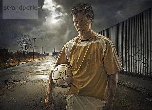 Illustration eines Fußballspielers  der einen Ball auf einer Straße hält