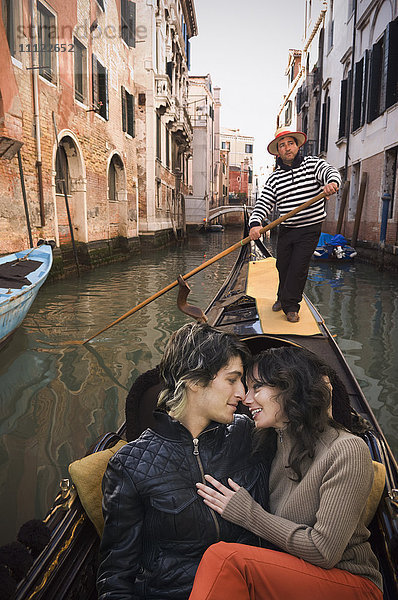 Romantisches italienisches Paar fährt in Gondel durch Kanal