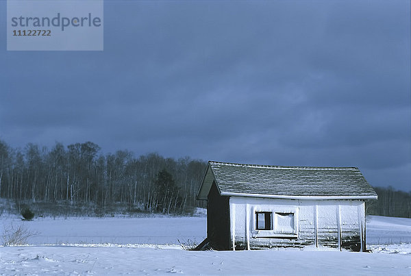 Haus in verschneiter ländlicher Landschaft