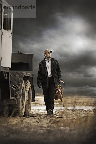 Kaukasischer Bauer geht an einem Lastwagen vorbei