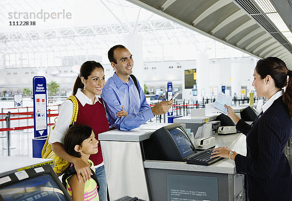 Hispanische Familie beim Einchecken am Flughafen