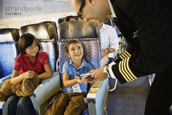 Flugbegleiterin hilft Kindern im Flugzeug