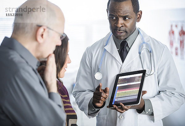 Arzt zeigt Patienten Tablet-Computer