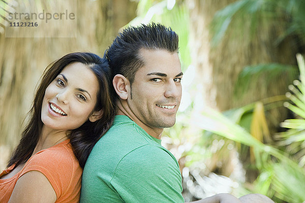Hispanisches Paar entspannt sich in tropischer Umgebung