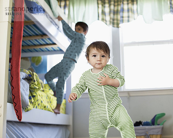 Hispanisches Kleinkind im Schlafzimmer stehend