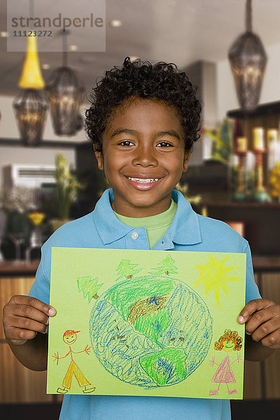 Afrikanischer Junge hält Zeichnung der Erde