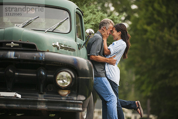 Paar küsst sich im Freien vor einem Lastwagen