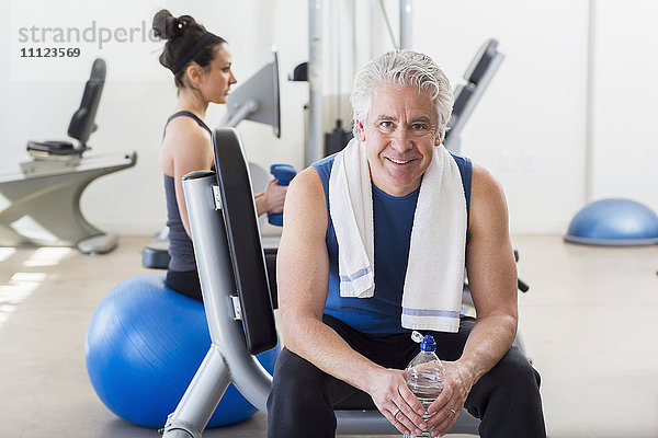 Älterer hispanischer Mann lächelnd im Fitnessstudio