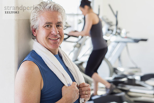 Älterer hispanischer Mann lächelnd im Fitnessstudio