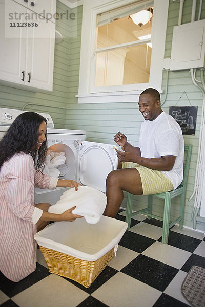 Afrikanischer Ehemann hilft seiner Frau beim Zusammenlegen der Wäsche