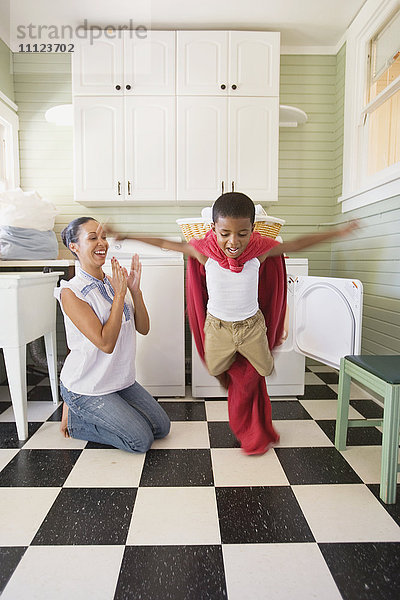 Gemischtrassige Mutter und Sohn spielen mit Wäsche