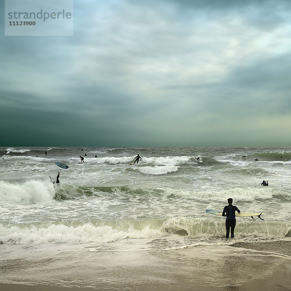 Menschen surfen im stürmischen Meer