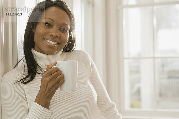 Afrikanische Frau hält Kaffeetasse