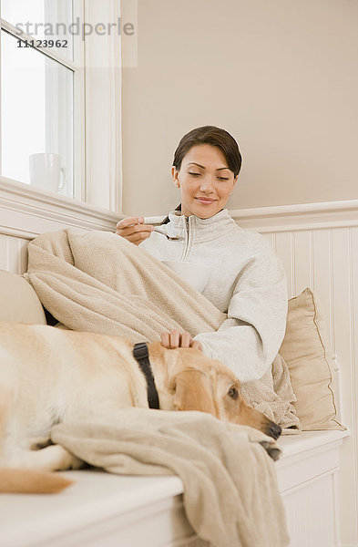 Hispanische Frau streichelt Hund