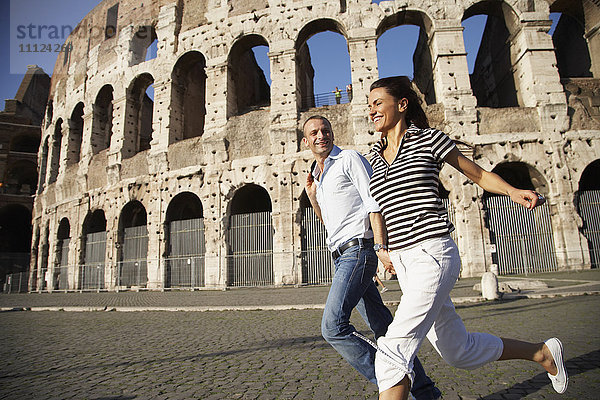 Touristenpaar läuft in der Nähe des Kolosseums
