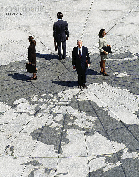 Geschäftsleute stehen auf einer Weltkarte
