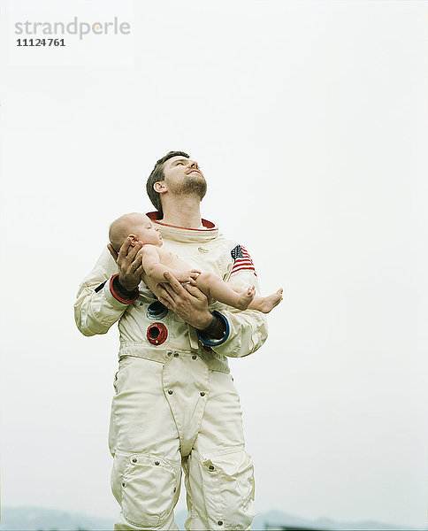 Astronaut hält Baby im Freien