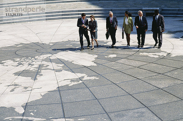 Geschäftsleute  die auf einer Weltkarte spazieren gehen