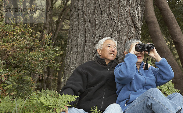 Älteres asiatisches Paar mit Fernglas im Freien