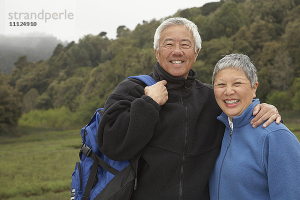 Älteres asiatisches Paar mit Rucksack im Freien