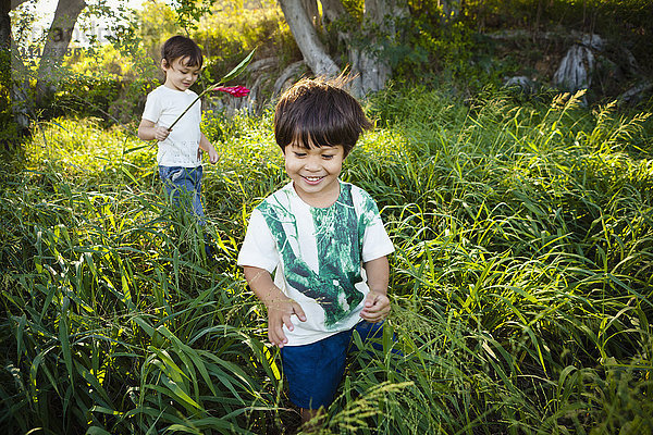 Gemischtrassige Kinder laufen durch hohes Gras