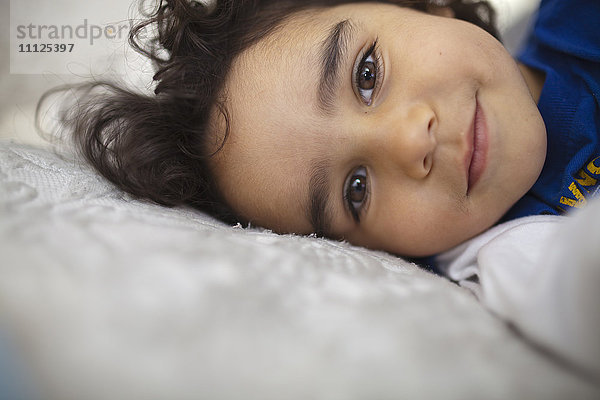 Gemischtrassiger Junge liegt im Bett