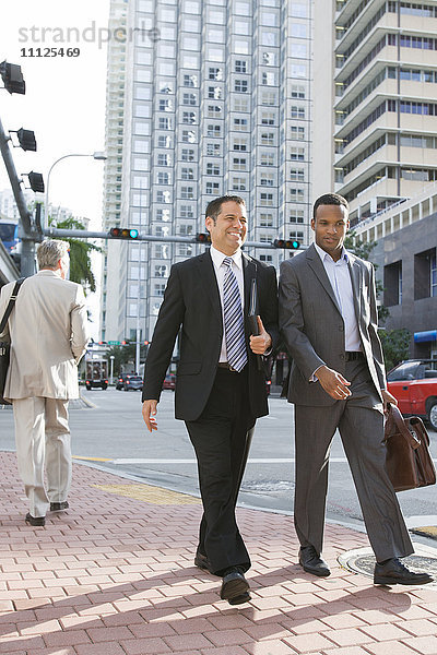 Geschäftsleute gehen zusammen auf einer Straße in der Stadt