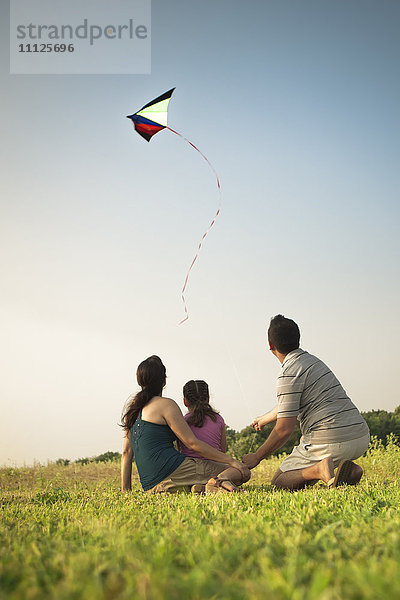 Familie beobachtet Drachen am Himmel