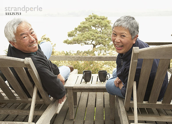 Älteres asiatisches Paar lächelt im Freien