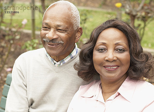 Älteres afrikanisches Paar  das sich im Freien umarmt und lächelt