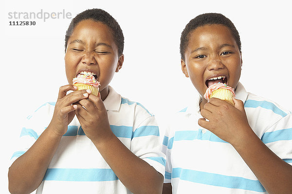 Junge afrikanische Zwillingsbrüder essen Muffins