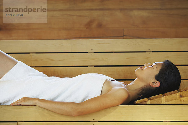 Asiatische Frau entspannt sich in der Sauna