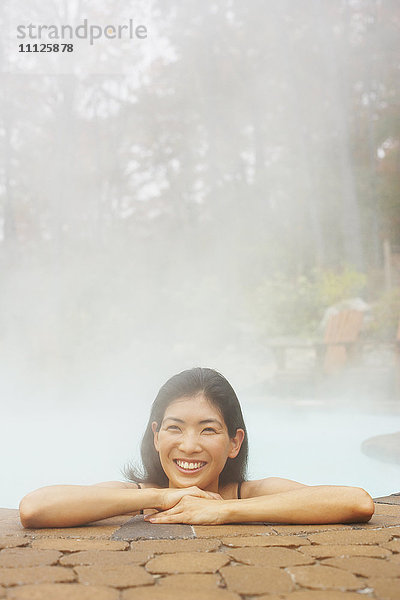 Asiatische Frau sitzt im Whirlpool
