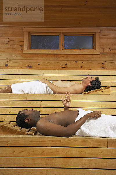 Zwei multiethnische Männer entspannen sich in der Sauna