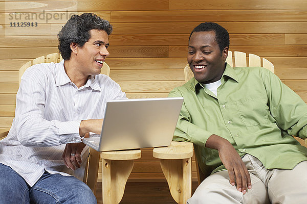 Zwei multiethnische Männer vor einem Laptop