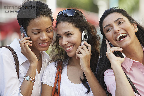 Multiethnische Frauen  die mit ihren Handys telefonieren
