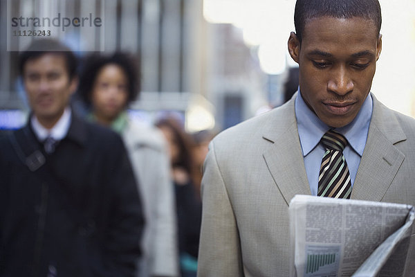 Afroamerikanischer Geschäftsmann liest Zeitung