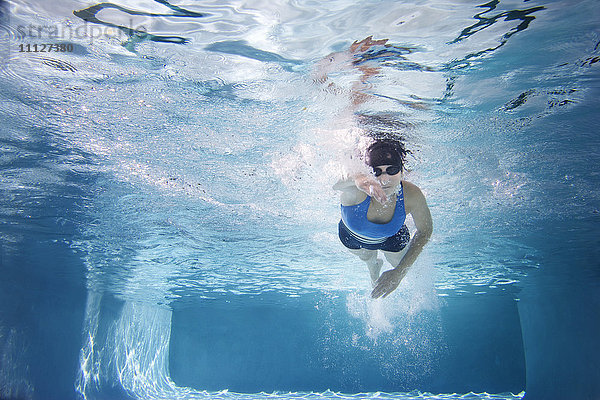 Kaukasische Frau schwimmt im Schwimmbad
