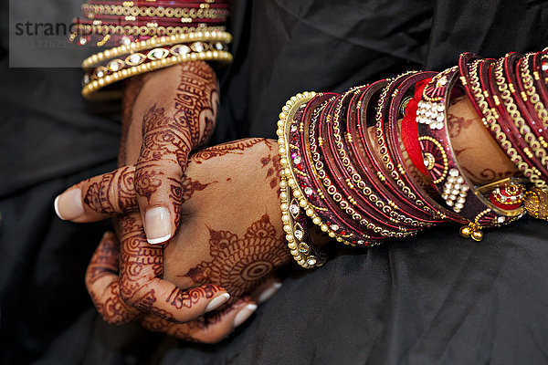 Nahaufnahme der Hände einer indischen Frau mit traditioneller Dekoration