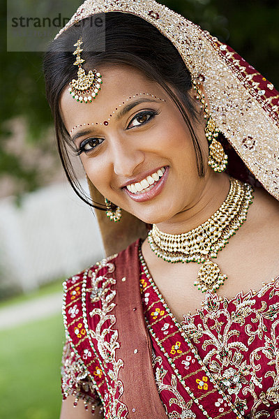 Lächelnde indische Frau in traditioneller Hochzeitskleidung