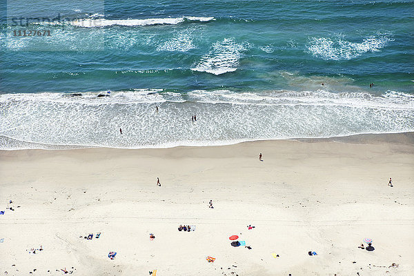 Menschen entspannen sich am sonnigen Strand