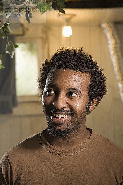 Afroamerikanischer Mann lächelnd mit Glühbirne über dem Kopf