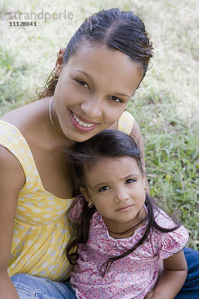 Hispanische Frau mit Tochter auf dem Schoß