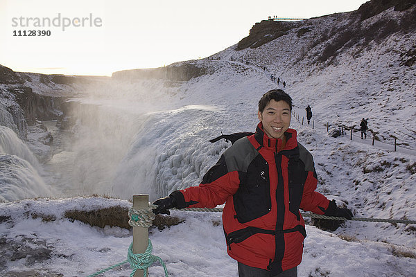 Chinesischer Mann steht auf einem abgelegenen Eisfeld