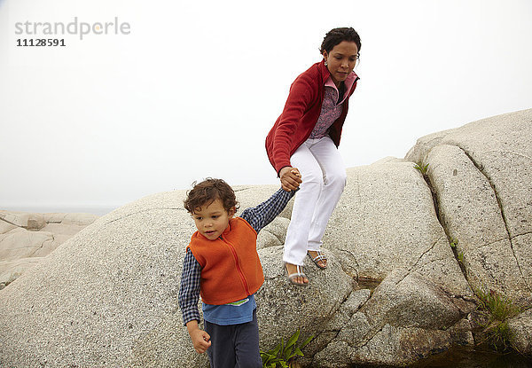 Mutter und Sohn klettern auf Felsen