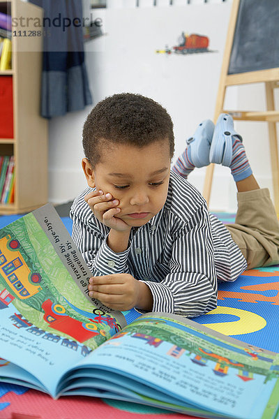 Gemischtrassiger Junge liest Märchenbuch