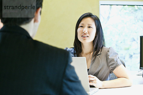 Asiatische Geschäftsfrau im Gespräch mit Mitarbeiterin