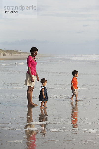 Mutter und Kinder genießen gemeinsam den Strand