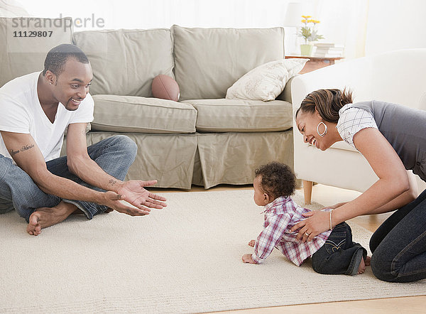 Afrikanisches Paar mit Baby im Wohnzimmer