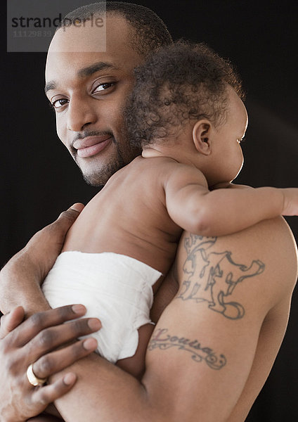 Afrikanischer Mann hält Baby